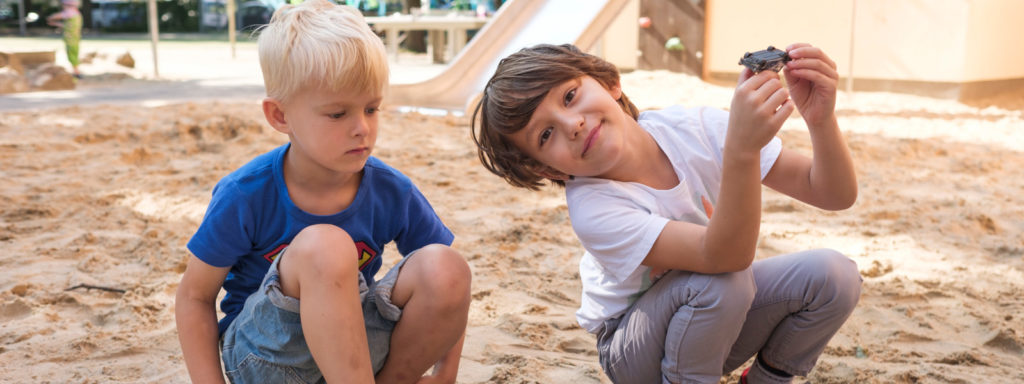 Zwei Kinder spielen im Sandkasten